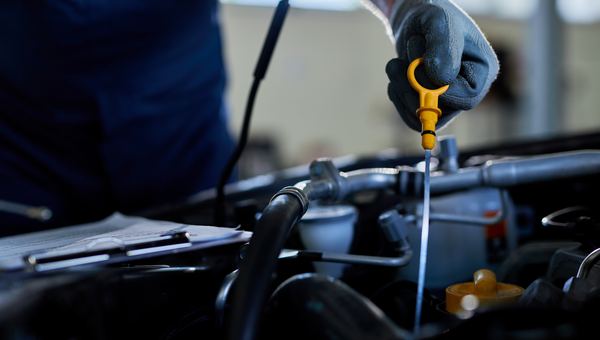 Ölwechsel – Mechaniker prüft den Ölstand
